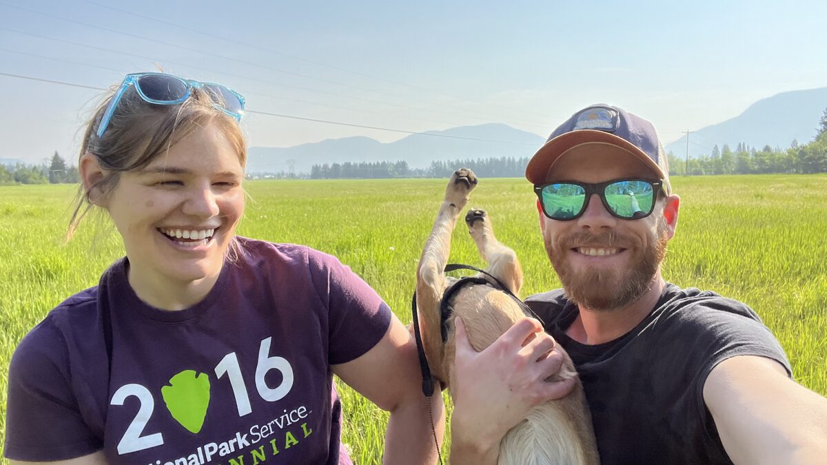 Mark with Beck and Sinopah in a Montana field, mountains behind.